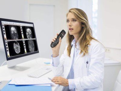 Medical practitioner dictating radiology notes into a handheld microphone